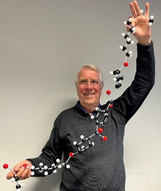 Professor Dick Broer holds up the molecule he invented as he teaches his grandchildren about liquid crystal theory.